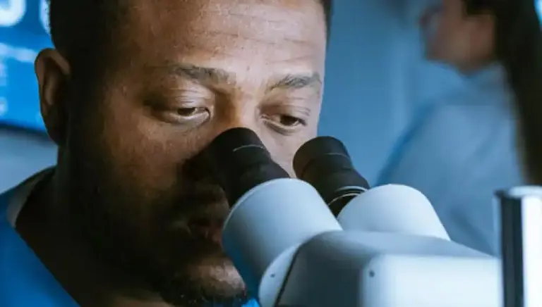 Close up of a scientist looking down a microscope