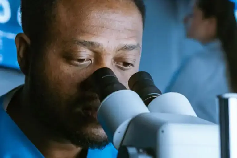 Close up of a scientist looking down a microscope