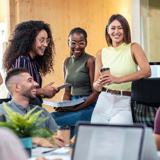 A mixed group of young people smiling and working in an office setting